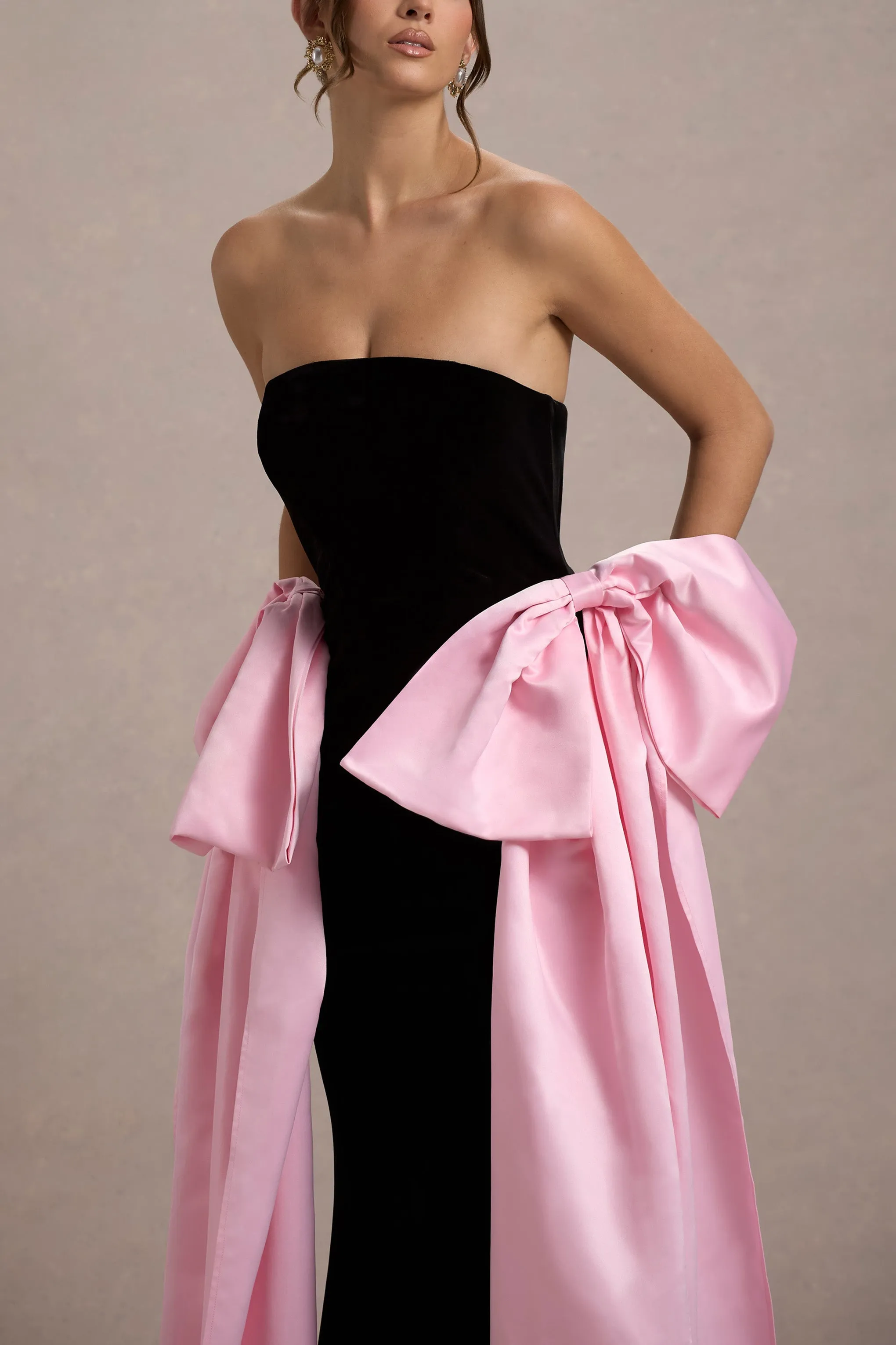 Attention | Robe longue noire sans bretelles avec nuds en satin rose.