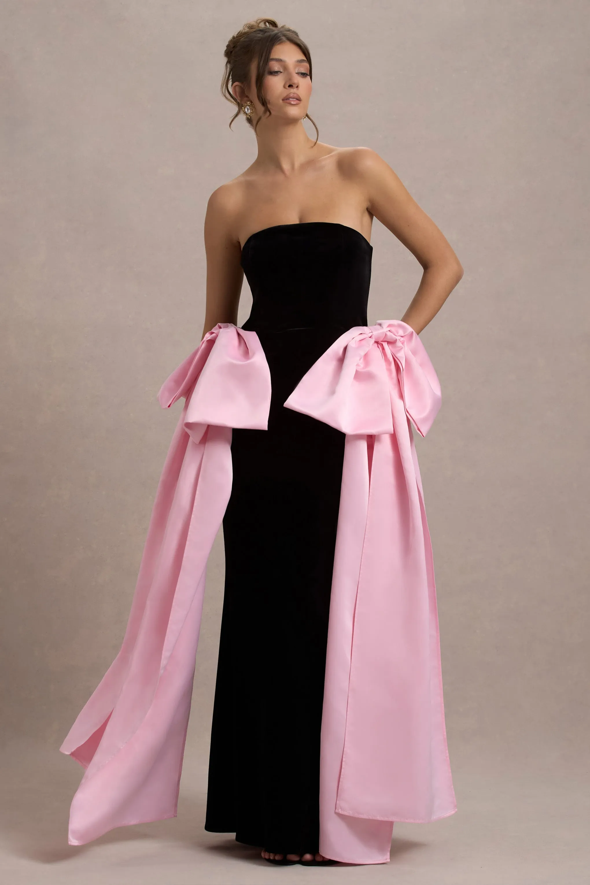 Attention | Robe longue noire sans bretelles avec nuds en satin rose.