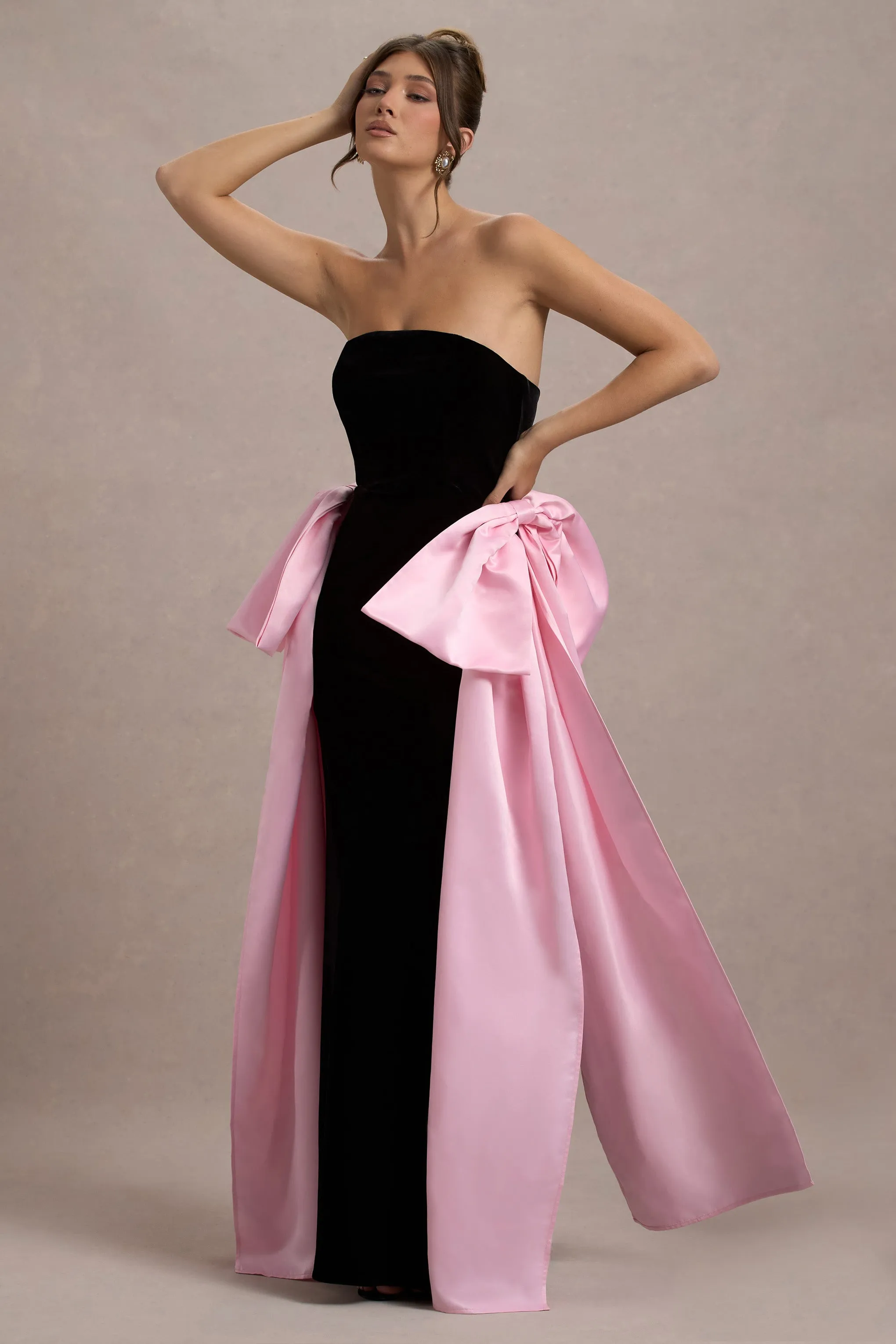 Attention | Robe longue noire sans bretelles avec nuds en satin rose.