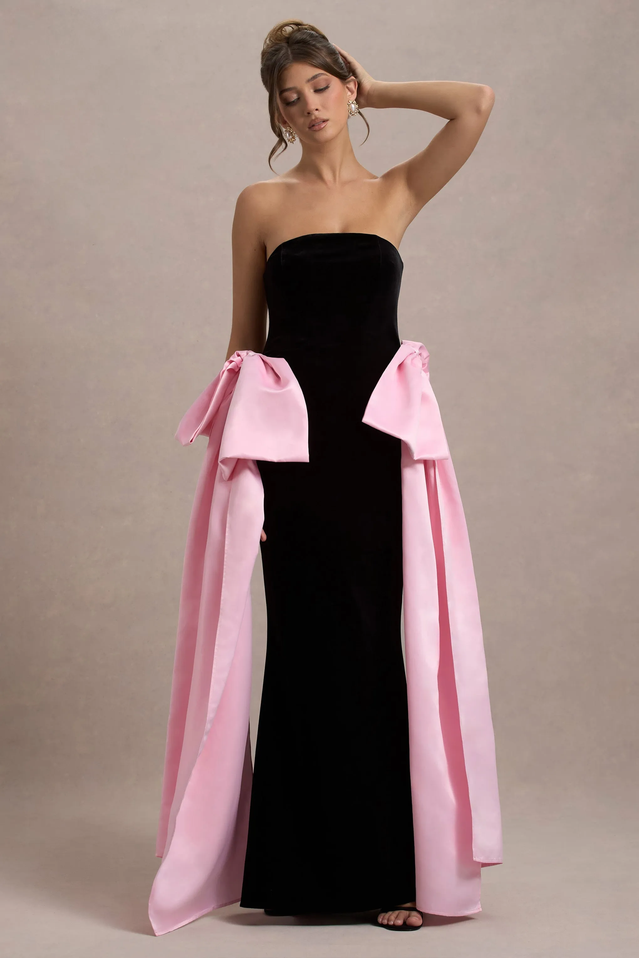 Attention | Robe longue noire sans bretelles avec nuds en satin rose.