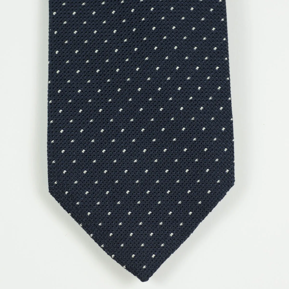 Loosely woven navy silk tie, small white dots