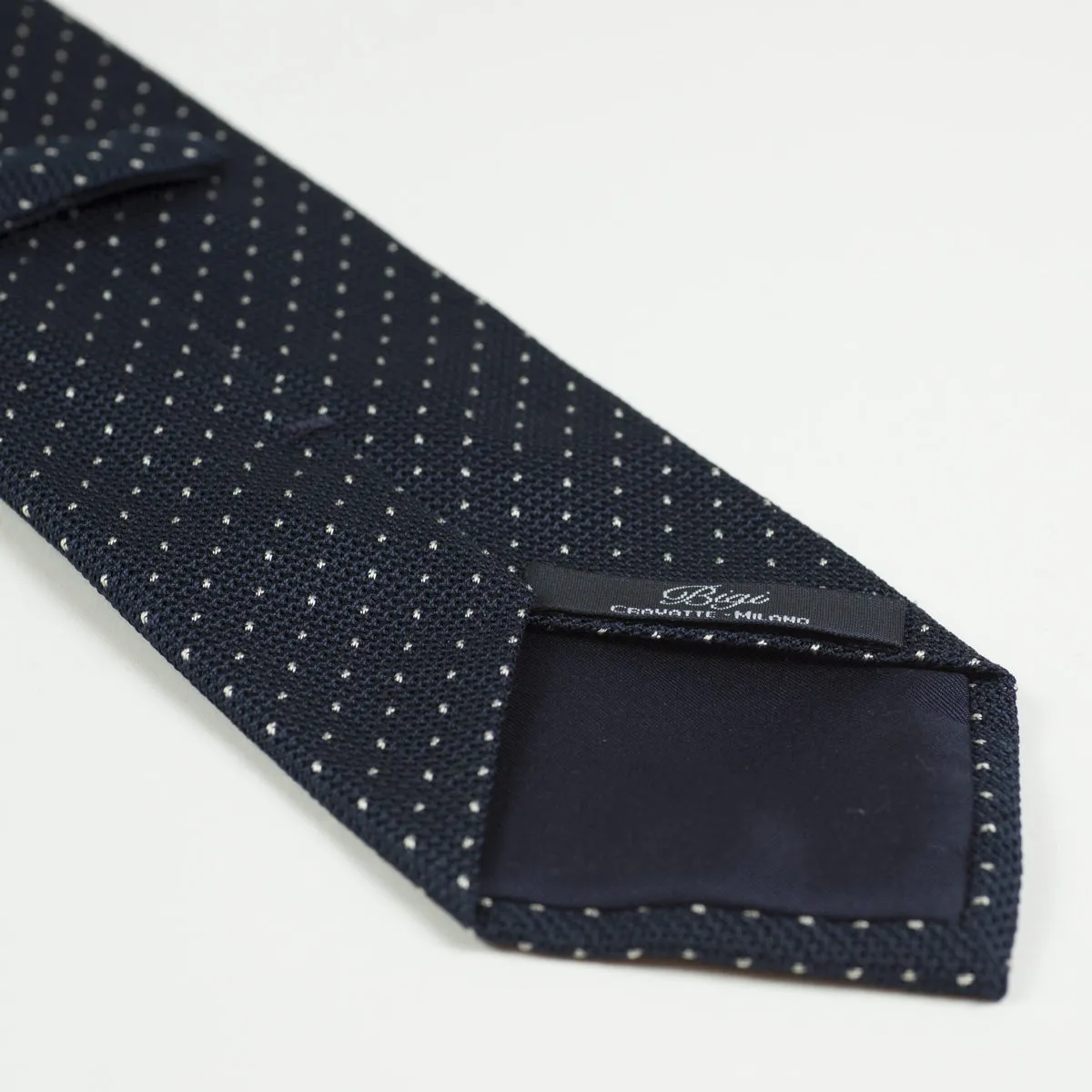 Loosely woven navy silk tie, small white dots