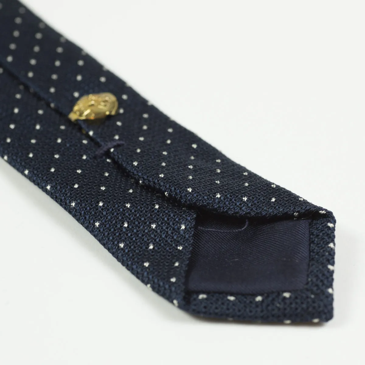 Loosely woven navy silk tie, small white dots